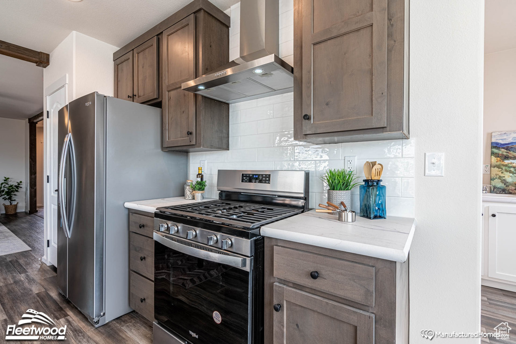 Kitchen with decorative backsplash, dark hardwood / wood-style flooring, wall chimney range hood, and stainless steel range with gas stovetop