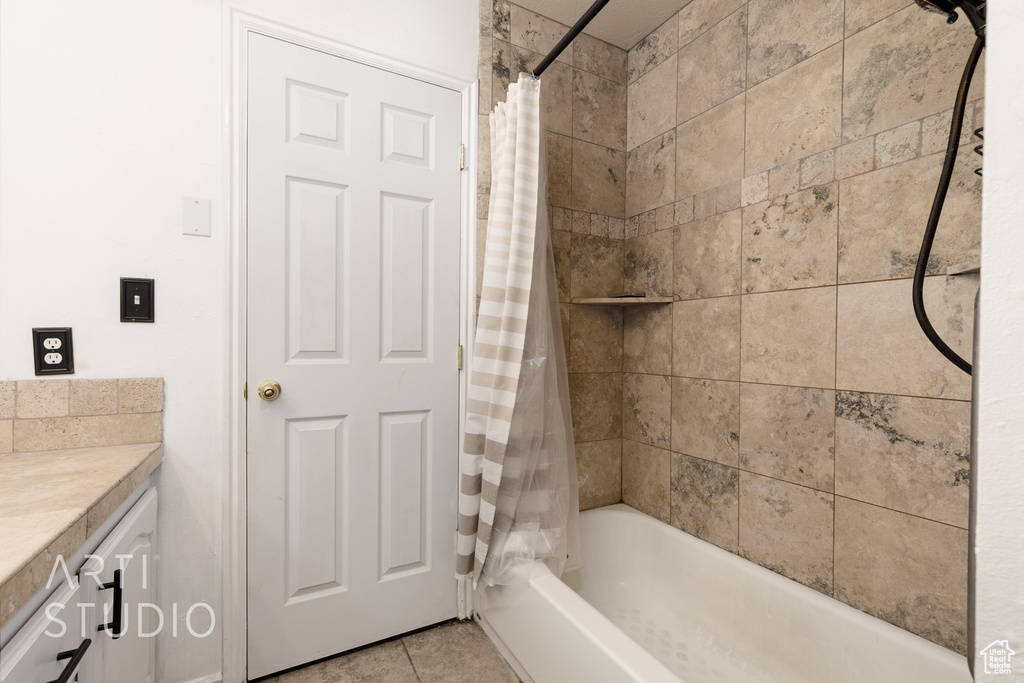 Bathroom with shower / bathtub combination with curtain, vanity, and tile patterned floors