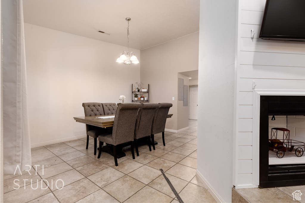 Dining area featuring light tile patterned floors and an inviting chandelier