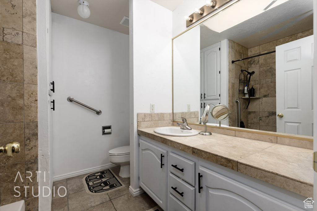 Bathroom with vanity, toilet, and tile patterned flooring