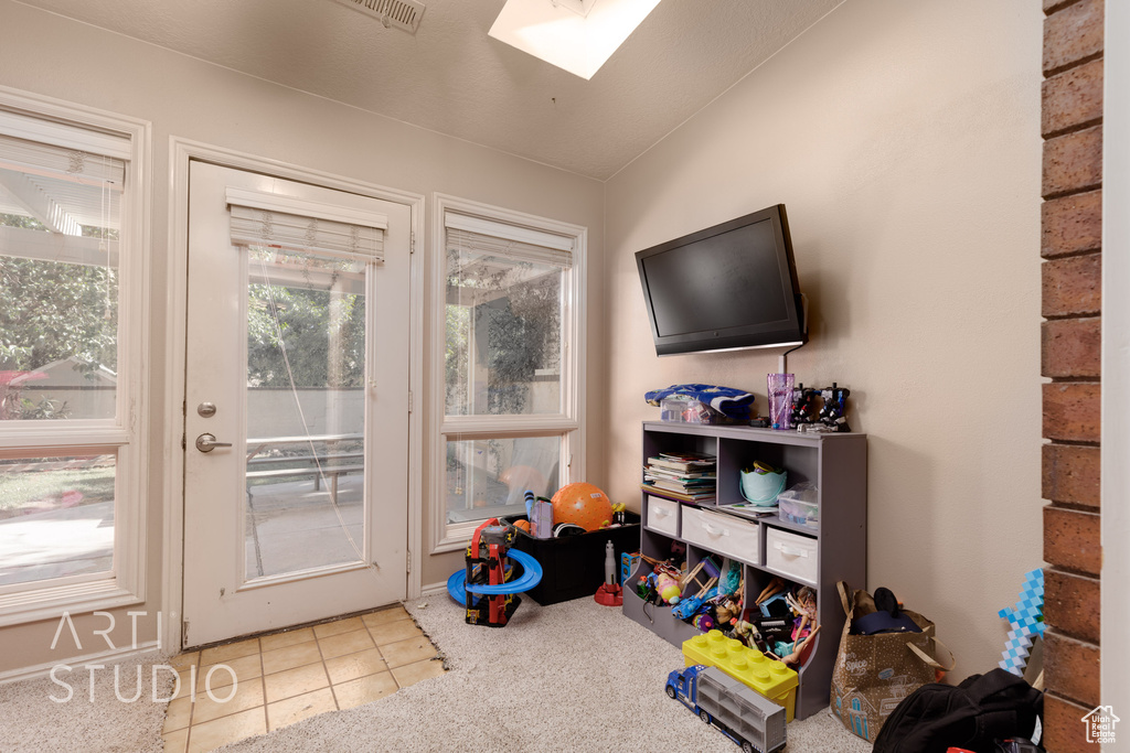 Doorway to outside with tile patterned floors and vaulted ceiling