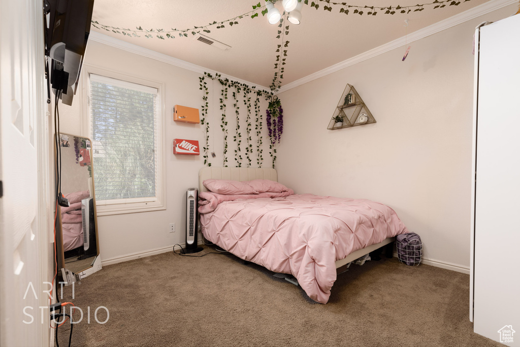 Bedroom featuring crown molding and carpet floors