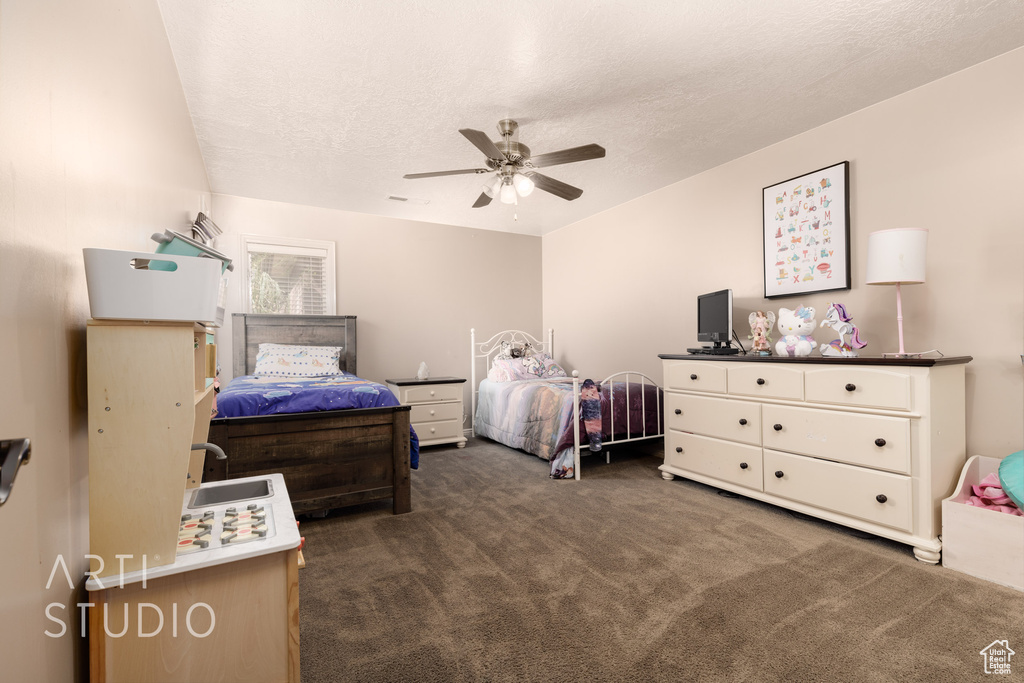 Bedroom with a textured ceiling, ceiling fan, and carpet floors