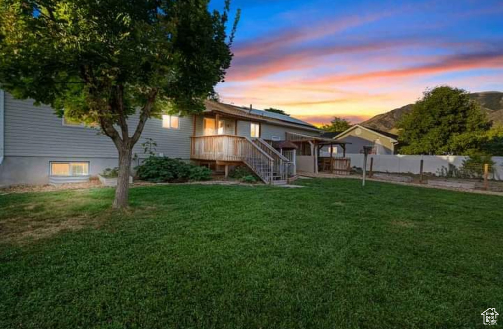 Back house at dusk with a yard