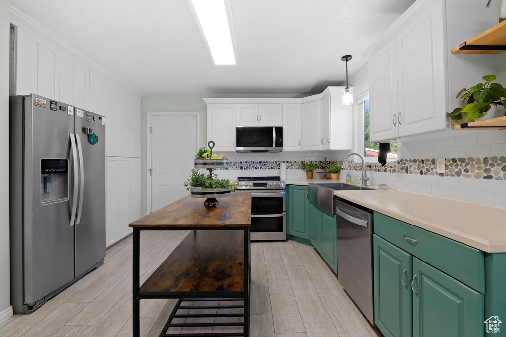 Kitchen featuring stainless steel appliances, pendant lighting, wood counters, white cabinets, and green cabinets