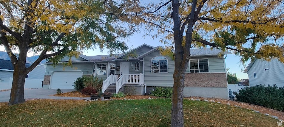 Ranch-style house featuring a front yard and a garage