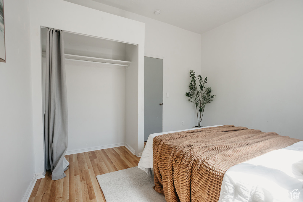 Bedroom with light wood-type flooring and a closet