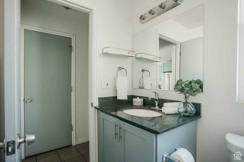 Bathroom with tile patterned floors, vanity, and toilet