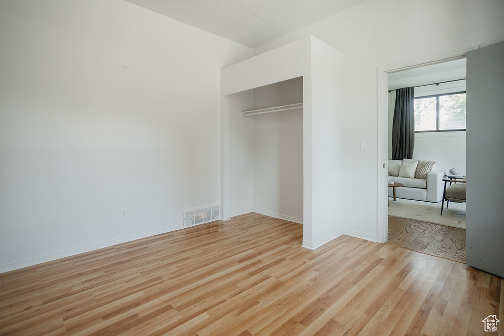 Unfurnished bedroom with a closet and light hardwood / wood-style floors