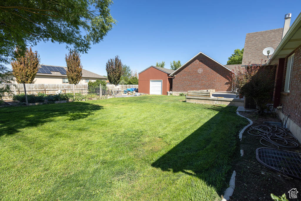 View of yard featuring a garage and an outbuilding