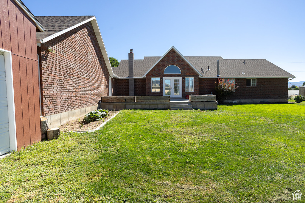 Back of house featuring french doors and a yard