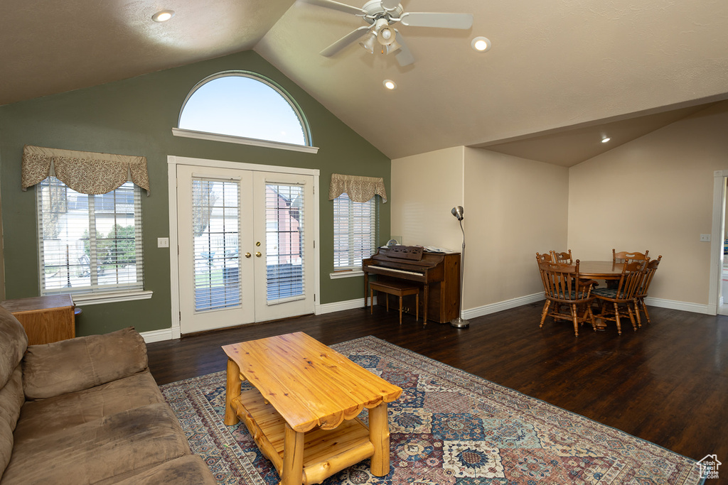 Living room featuring ceiling fan, high vaulted ceiling, dark wood-type flooring, and french doors