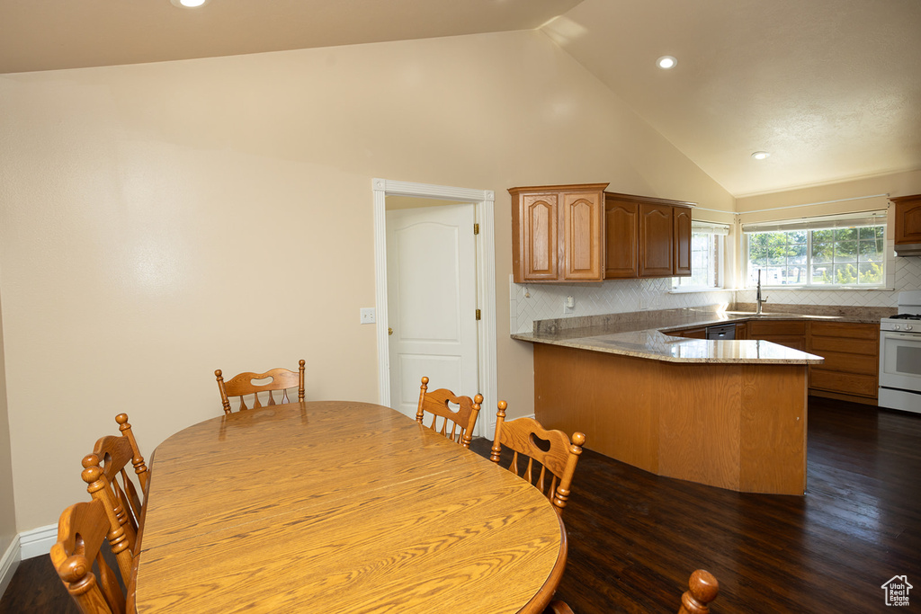 Unfurnished dining area featuring high vaulted ceiling and wood-type flooring