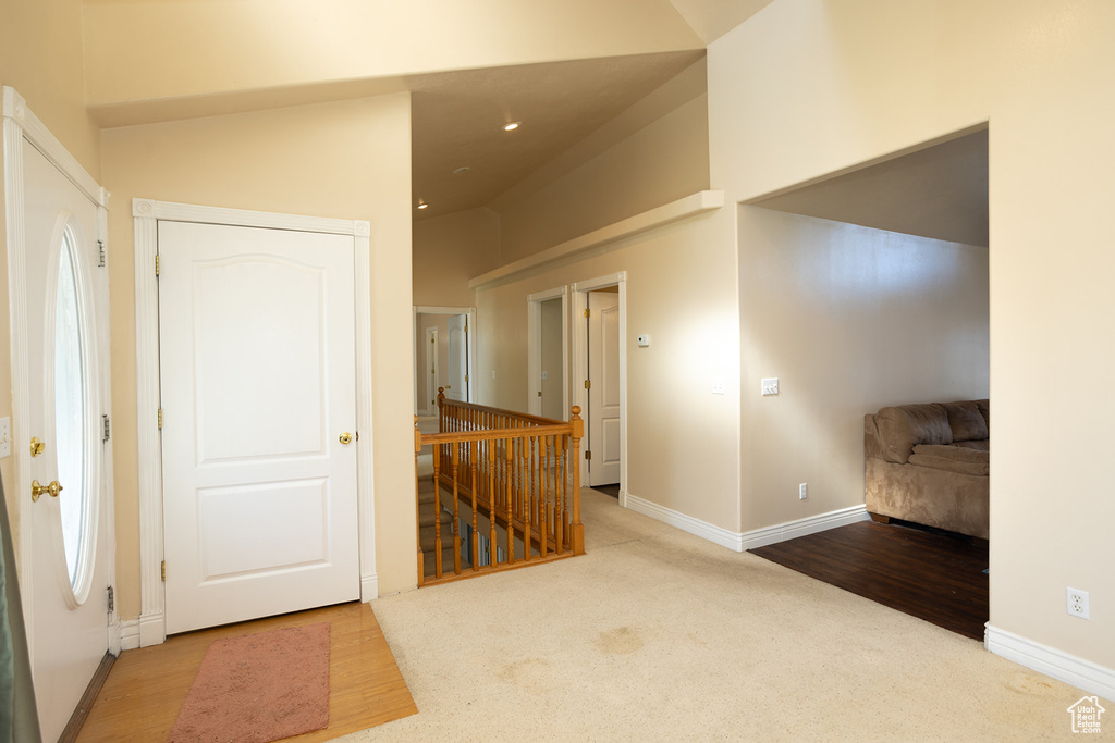 Carpeted entrance foyer with lofted ceiling