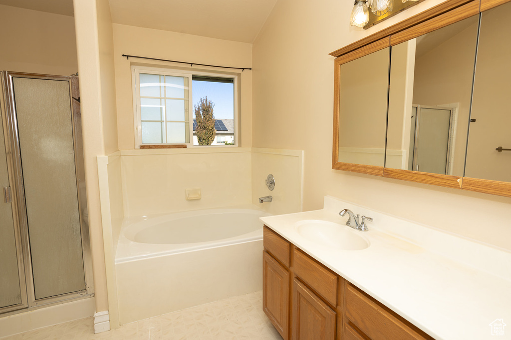 Bathroom with tile patterned floors, independent shower and bath, and vanity