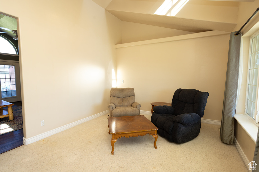 Living area featuring high vaulted ceiling and carpet flooring