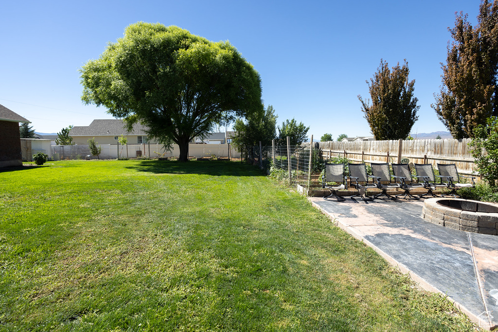 View of yard with an outdoor fire pit and a patio