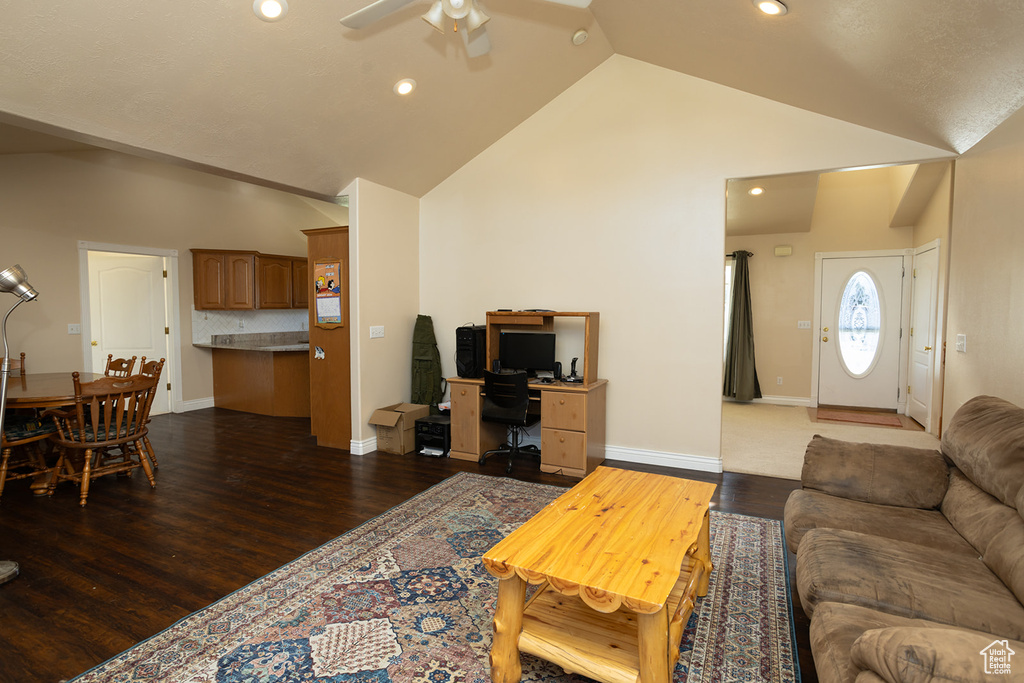 Living room featuring high vaulted ceiling, ceiling fan, and wood-type flooring