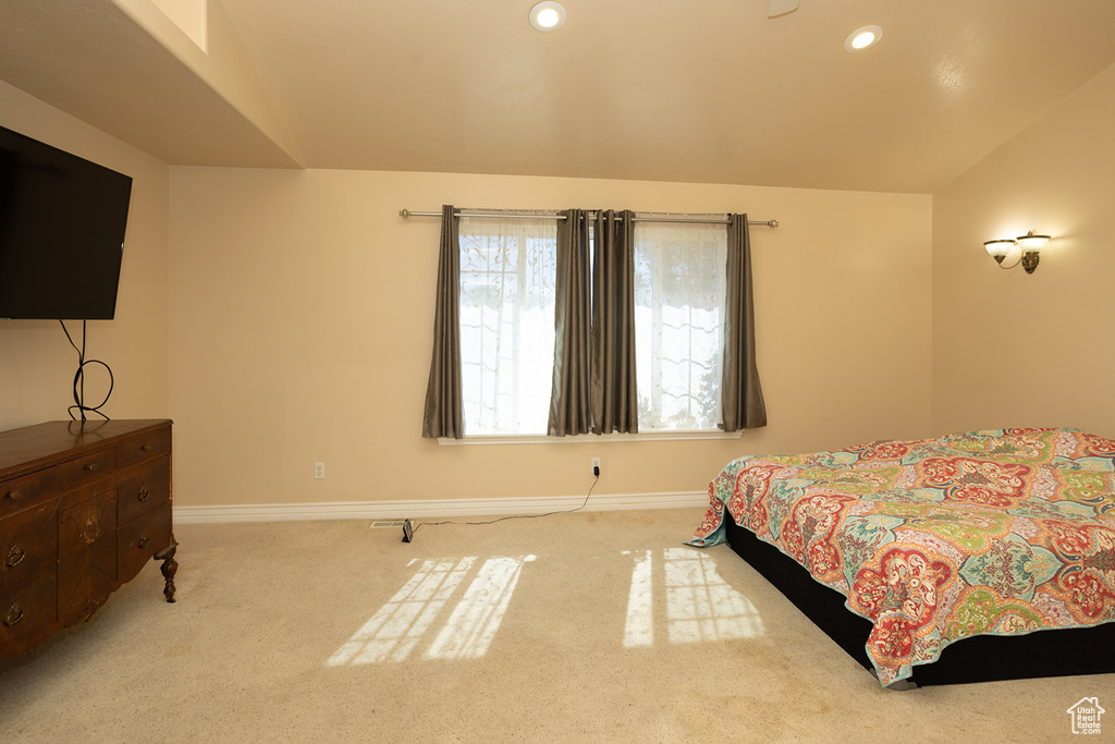 Bedroom with vaulted ceiling and light colored carpet