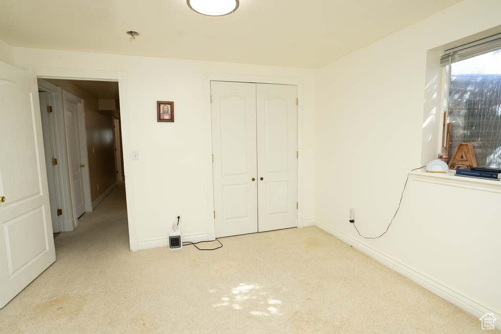 Unfurnished bedroom with a closet and light carpet