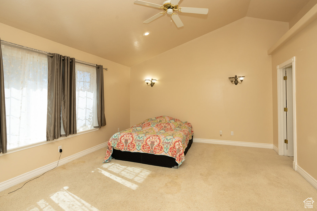 Carpeted bedroom featuring ceiling fan and lofted ceiling