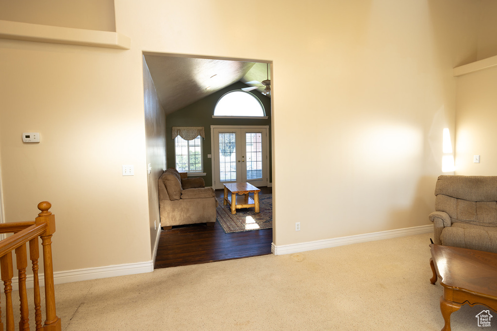 Living area with high vaulted ceiling and hardwood / wood-style flooring