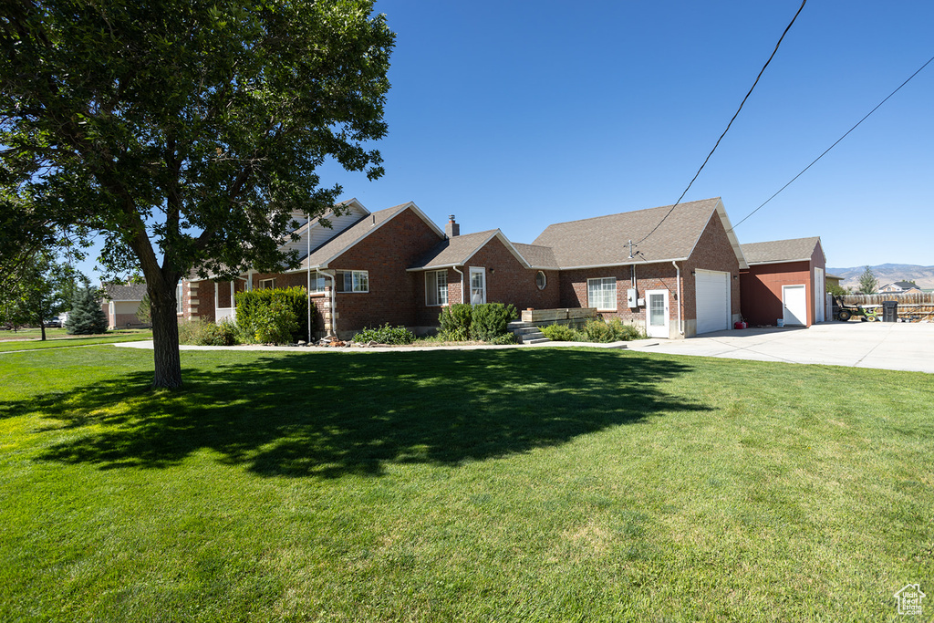 View of front of property with a front yard and a garage