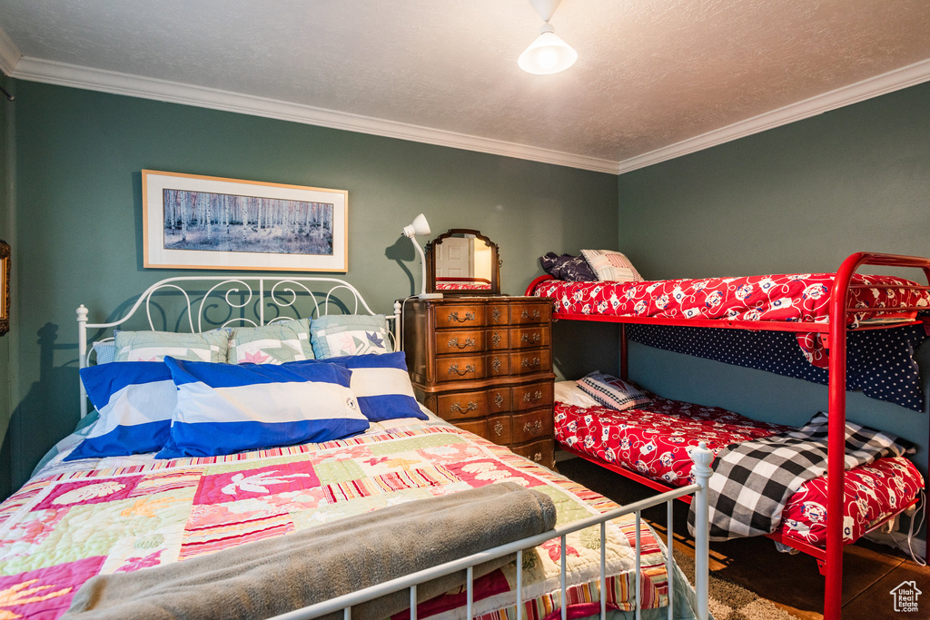 Bedroom with a textured ceiling and ornamental molding