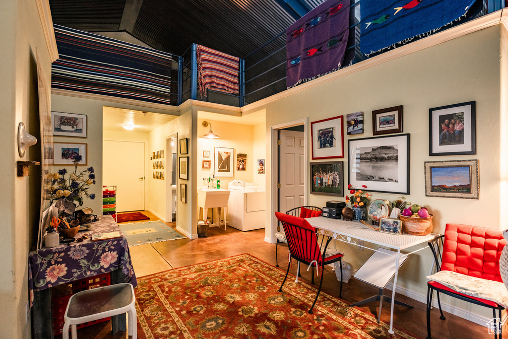 Tiled office space featuring a high ceiling and washing machine and clothes dryer