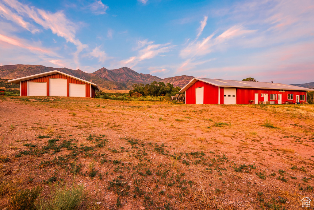 View of yard featuring a mountain view, a garage, and an outbuilding