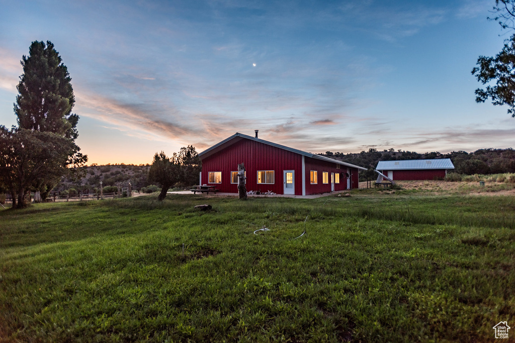 Back house at dusk with a yard