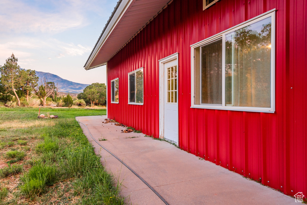 View of side of home with a lawn and a mountain view