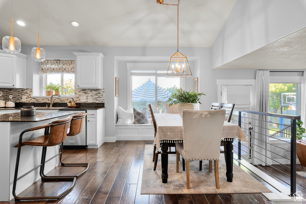 Dining area featuring dark hardwood / wood-style floors, a chandelier, sink, and a healthy amount of sunlight