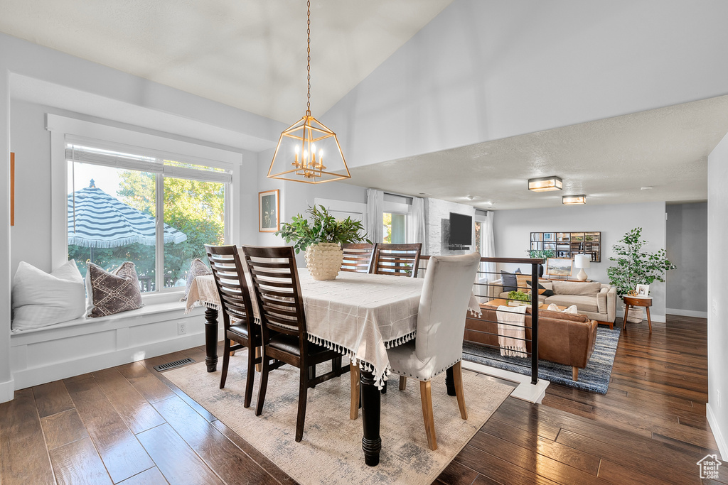 Dining space featuring an inviting chandelier and dark wood-type flooring