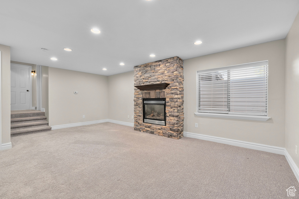 Unfurnished living room with light carpet and a fireplace