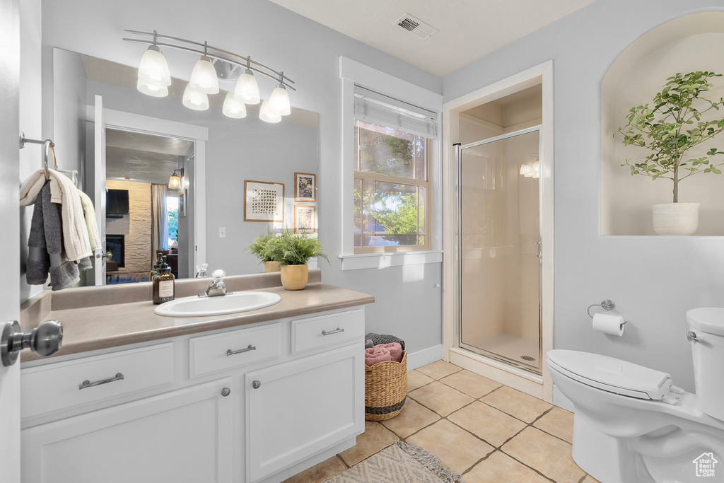 Bathroom featuring a fireplace, an enclosed shower, tile patterned floors, vanity, and toilet