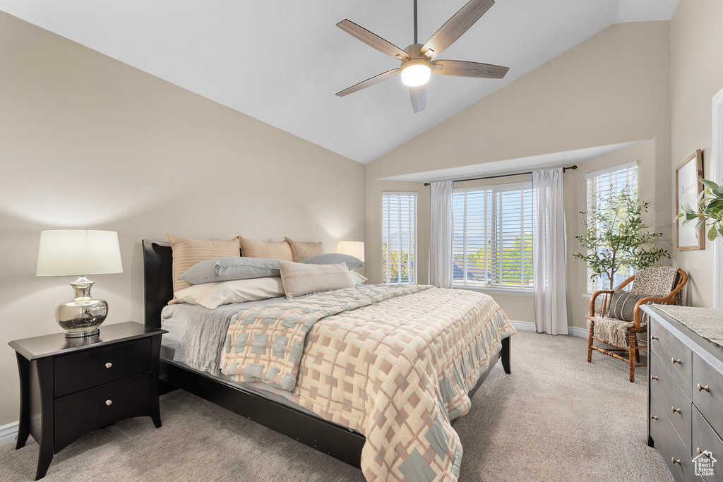 Bedroom featuring ceiling fan, light carpet, and high vaulted ceiling