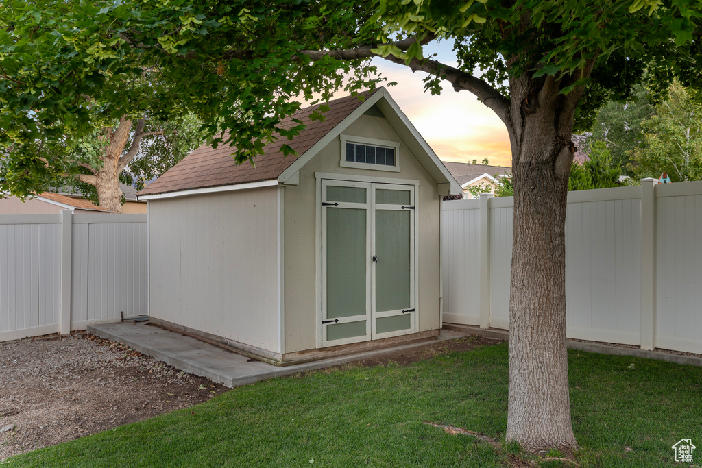 Outdoor structure at dusk featuring a lawn