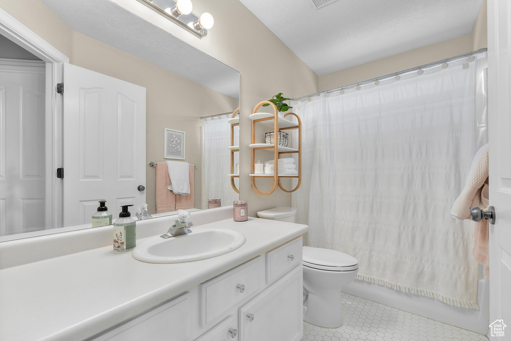 Bathroom with tile patterned flooring, toilet, and vanity