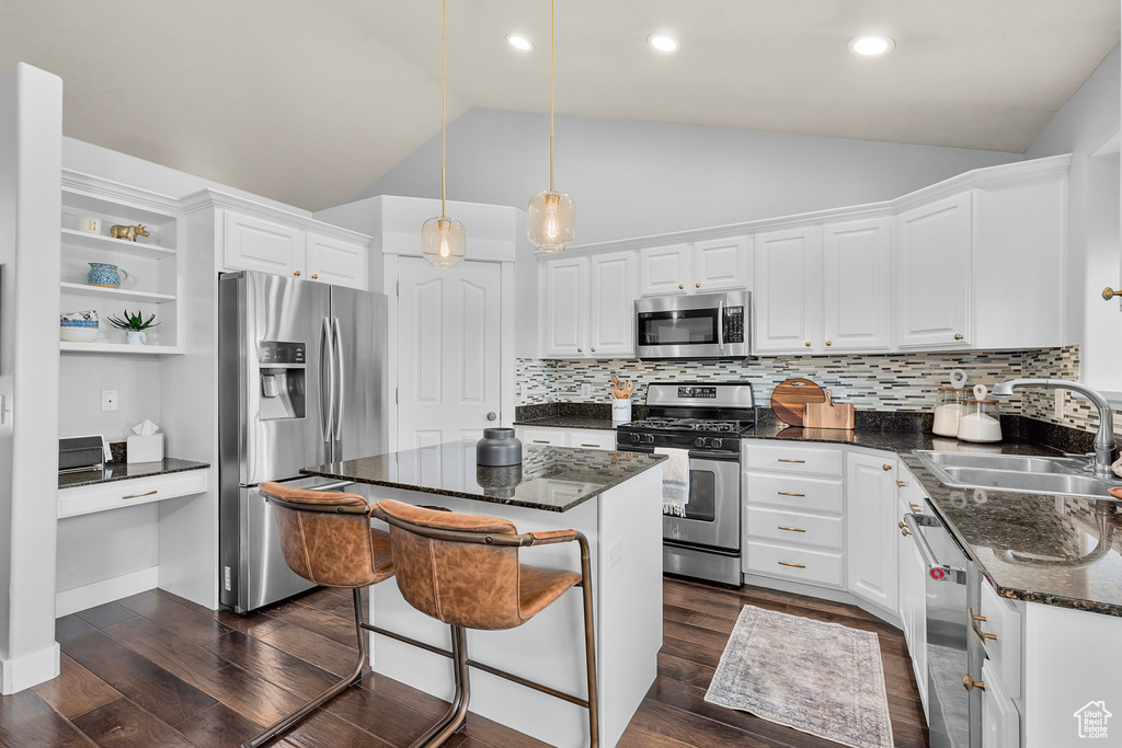 Kitchen featuring appliances with stainless steel finishes, a center island, and white cabinets