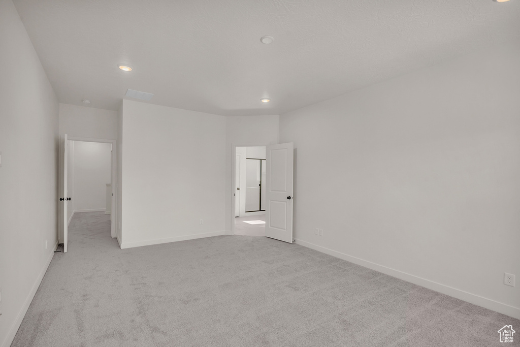 Empty room featuring light colored carpet