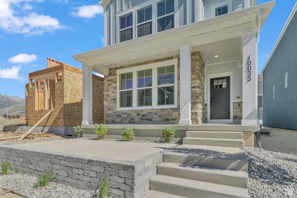 Doorway to property featuring a mountain view and covered porch