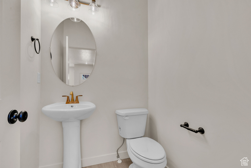 Bathroom with wood-type flooring, sink, and toilet