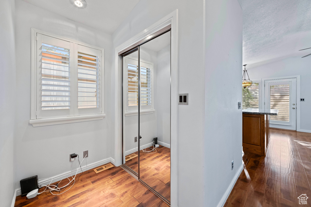 Hallway featuring plenty of natural light, a textured ceiling, and dark hardwood / wood-style floors