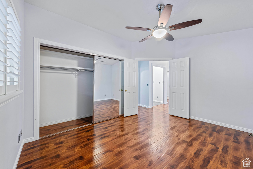 Unfurnished bedroom with ceiling fan, hardwood / wood-style flooring, and a closet