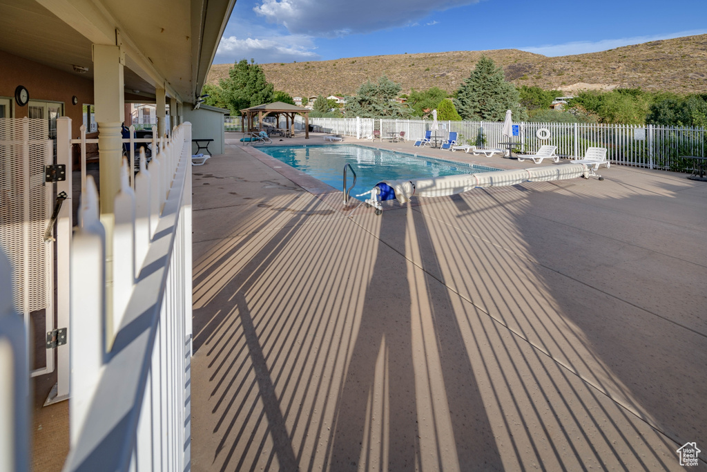 View of swimming pool with a patio and a mountain view