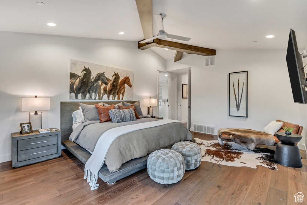 Bedroom with vaulted ceiling with beams and hardwood / wood-style flooring