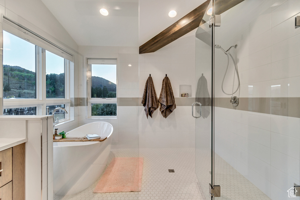 Bathroom with independent shower and bath, vanity, and tile walls