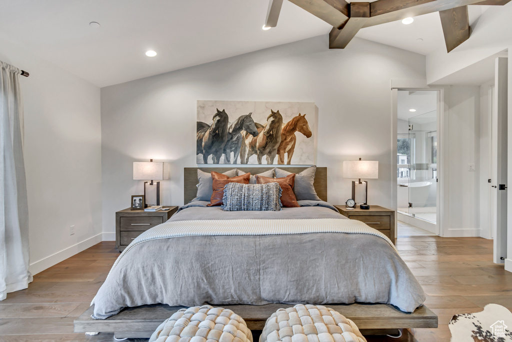 Bedroom with light hardwood / wood-style floors and vaulted ceiling with beams