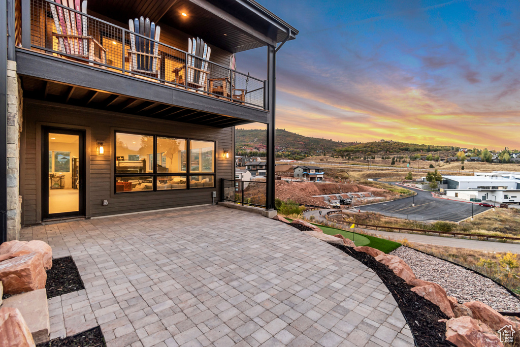 Patio terrace at dusk featuring a balcony